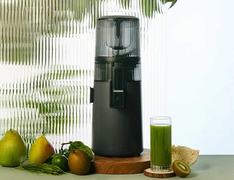 Hurom H70FT mit frischem Obst und einem Glas grünem Saft